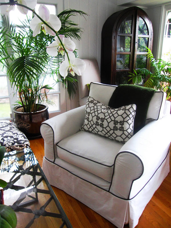 White denim slipcovered armchair with chocolate brown piping in a living room