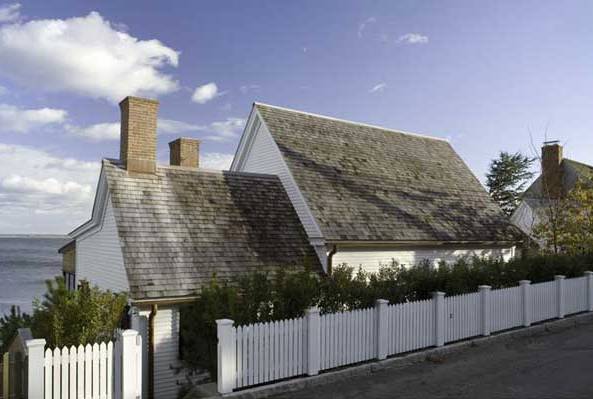 Exterior of a beach house by Stephan Jaklitsch with a white picket fence