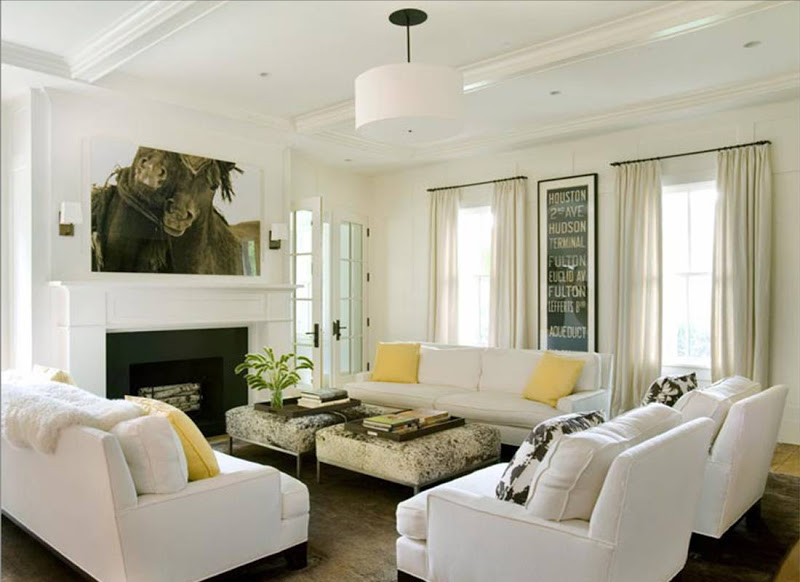 White living room with coffered ceiling, dueling sofas with yellow accent pillows and a white drum pendant light