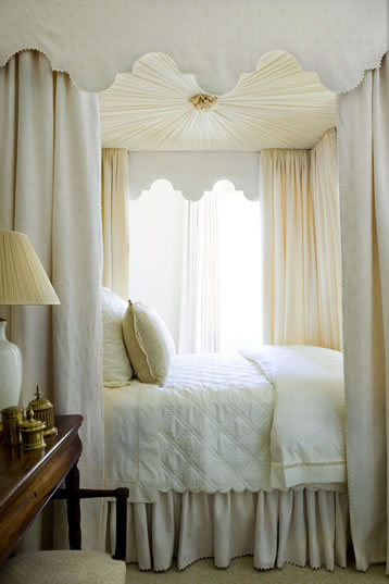 White bedroom with an elegant canopy bed