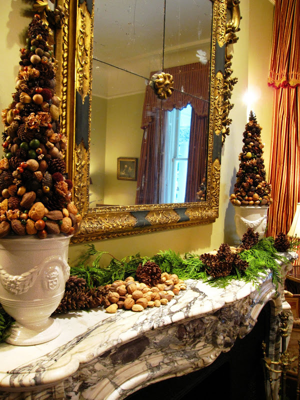 Fireplace in the men's parlor of a historic New Orleans mansion with a garland made of fresh pine, pine cones and nuts and a nut topiary