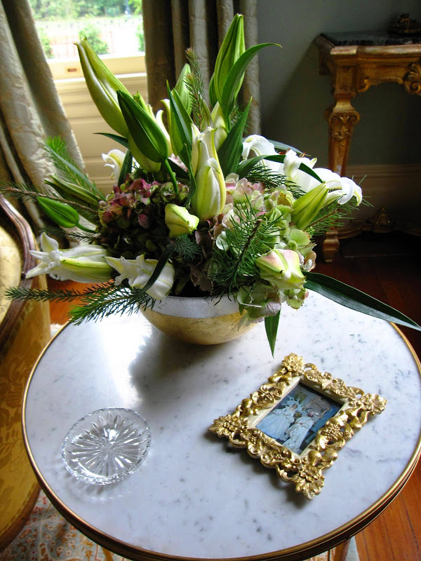 Ladies parlor in a historic New Orleans mansion with a flower arrangement in a porcelain bowl with hydrangeas and white star gazer lilies and pine sprigs