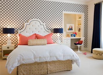 Bedroom by Massucco Warner Miller with blue and white lattice print wallpaper, dark blue curtains, white upholstered headboard with navy trim and coral accent pillows