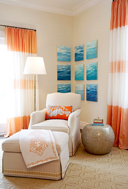 Bedroom by Massucco Warner Miller with orange and cream striped curtains, a white armchair with matching ottoman and an orange accent pillow