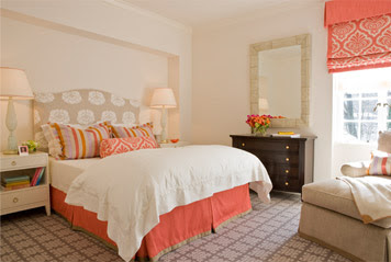 Bedroom by Massucco Warner Miller with coral roman shades, bead skirt and and accent pillows, grey graphic print carpet and a taupe and white headboard