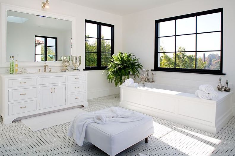 Black and white Master bathroom in a Spanish revival home with white freestanding tub and black paned windows