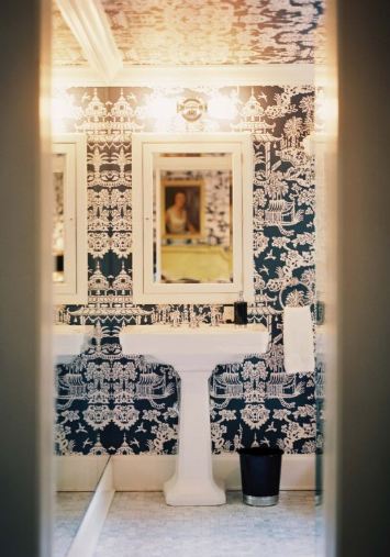 Guest bathroom with toile wallpaper and a pedestal sink 
