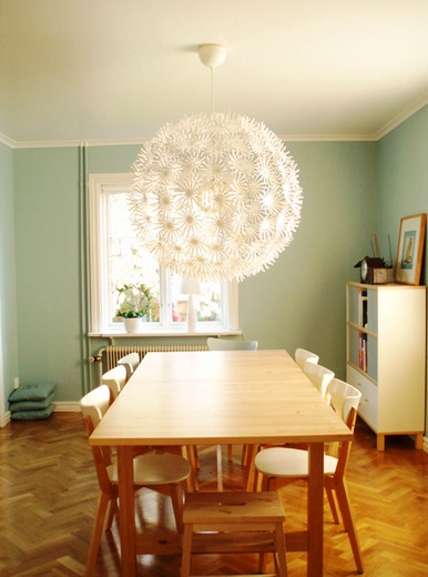 Light blue kitchen with herringbone wood floor and a Dandelion ceiling light from Ikea