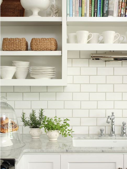 Close up of the kitchen with white subway tile backplash and carrara marble counter