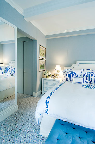 Master bedroom with crisp white monogrammed linens, a majestic white headboard and clean white furniture