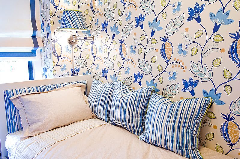 Guest bedroom with colorful floral wallpaper, striped headboard and matching accent pillows