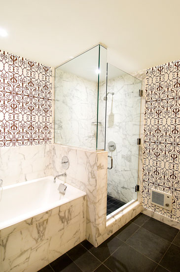 Bathroom with carrara marble tub and shower and brown and white scroll work walls