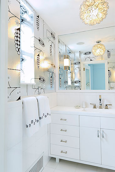 Modern bathroom with silver metallic wallpaper and a lotus pendant light