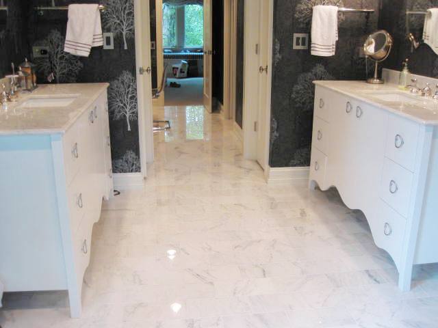 Black master bathroom with white cabinets and moldings and Carrara marble floor