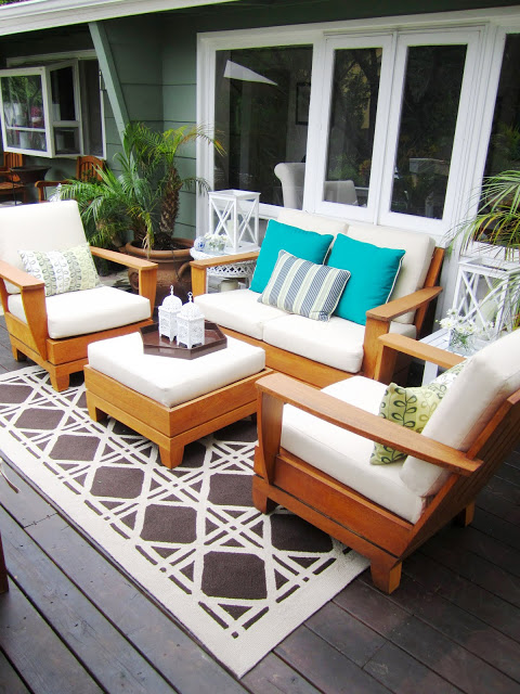 Outdoor living room with cane pattern rug and pops of color 