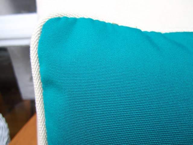 Close up of turquoise pillow with white trim