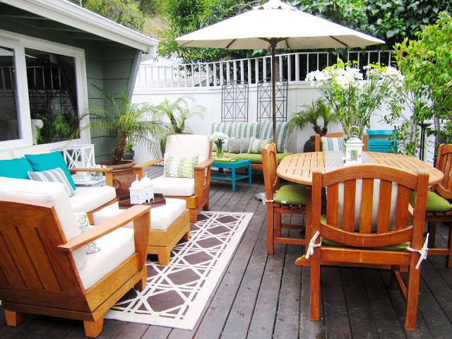 Outdoor deck with refurbished and painted furniture and brightly colored accessories