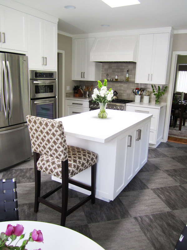 Gourmet kitchen with Thermador oven, grey/brown backsplash, white paneled cabinets and hood and grey tiles arranged in a diamond pattern