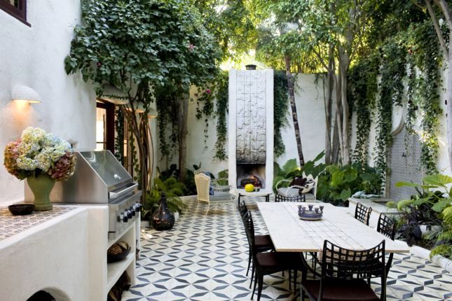 Outdoor courtyard with tile floor, grand modern silver fountain, a lounge area and dining room