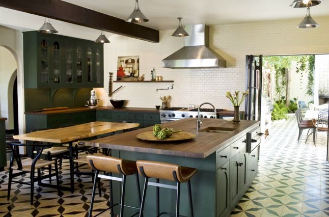 Eat in kitchen with mosaic tile floor, white subway tile backsplash, dark green cabinets and matching island with butcher block top