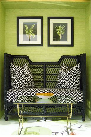 Cozy nook with green seagrass wallpaper and wicker loveseat