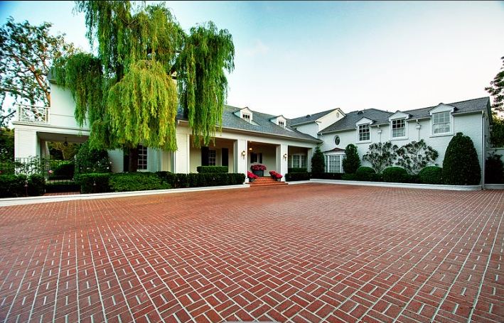 Brick driveway leads to a historic Paul Williams designed home in Holmby Hills