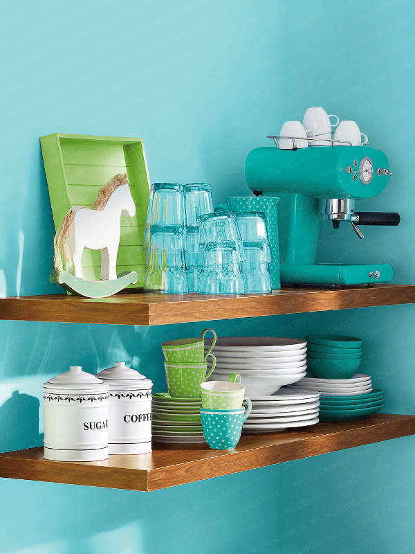 Floating shelves in a small turquoise kitchen with matching accessories