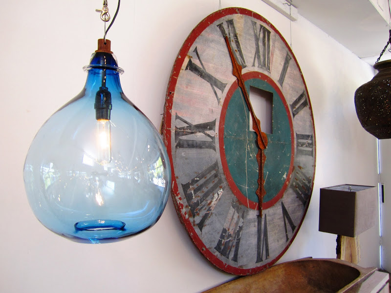 Blue glass jug pendant light and a large clock at Cisco Home in Brentwood