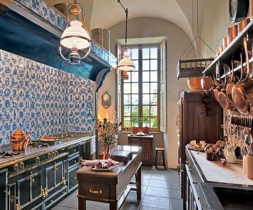 Kitchen in Château du Sailhant with copper pots and pans, La Cornue range and terra-cotta tiles
