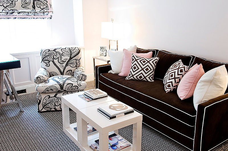 Living room designed by Christina Murphy with brown sofa with white piping and a black and white graphic armchair