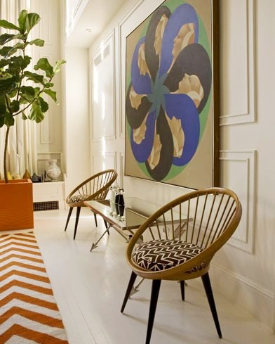Dining room in Jonathan Adler's NYC home with two round chairs and decorative wall molding