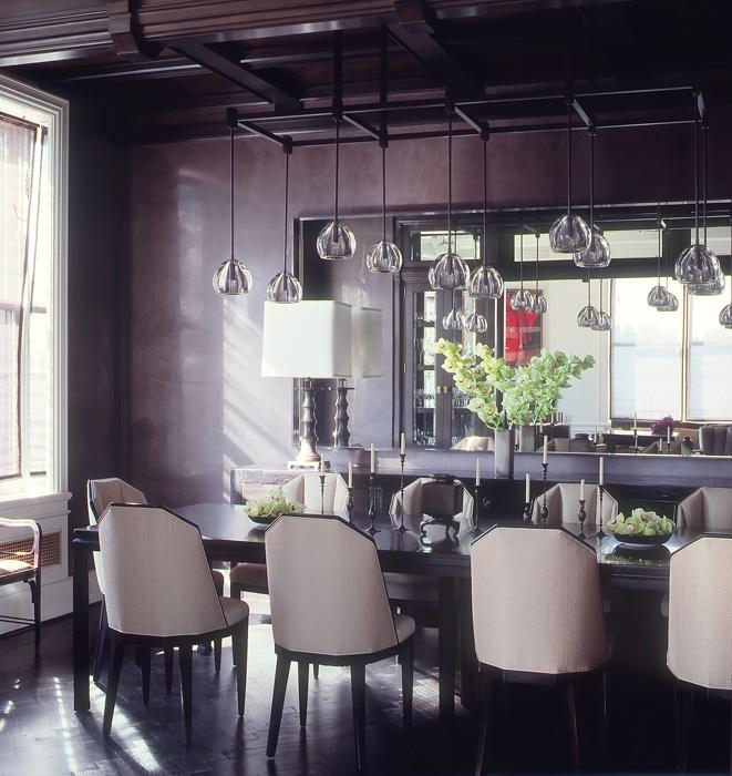 Elegant purple dining room with glass pendant lights, a long dark table and upholstered chairs