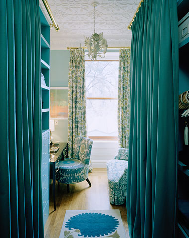 Dressing room with blue curtains to hide storage and closet space and molded ceiling