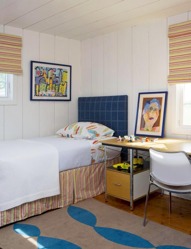 Bedroom in the Hamptons with blue plaid headboard and striped bed skirt with matching Roman curtains