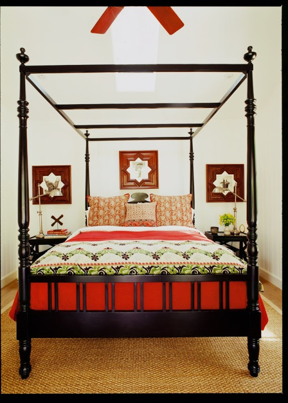 Bedroom by Martyn Lawrence Bullard with black canopy bed, Moroccan star mirrors and a sisal rug