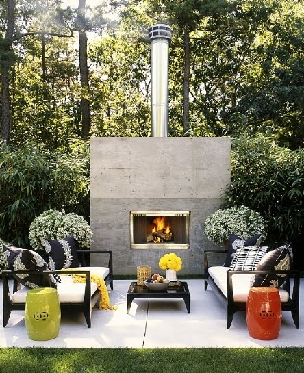 Outdoor patio with black furniture, green and orange garden stools,a fireplace and lots of planets