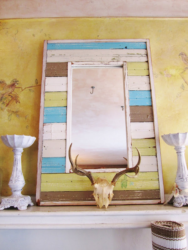 Mantel with distressed painted wood frame mirror, deer skull and candlesticks