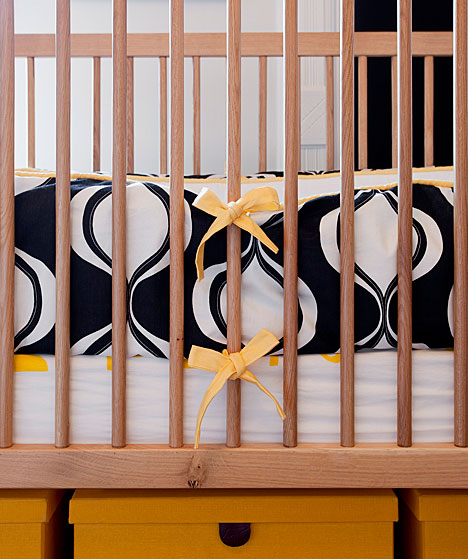 Close up of a crib with yellow and navy bedding