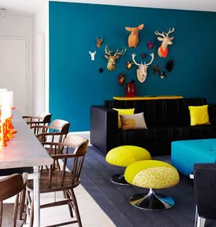 Modern living room with "trophy wall" with an assortment of brightly colored fake deer and buck heads