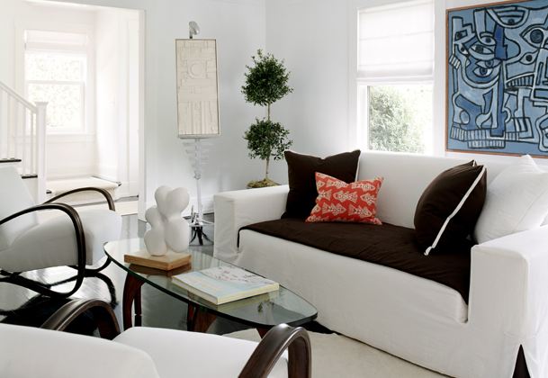 White living room with white sofas and armchairs with dark tailored seat cushions