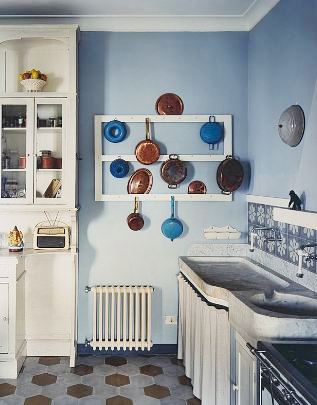Blue kitchen in an Italian villa with hexagon tile floor and a wall mounted pot rack