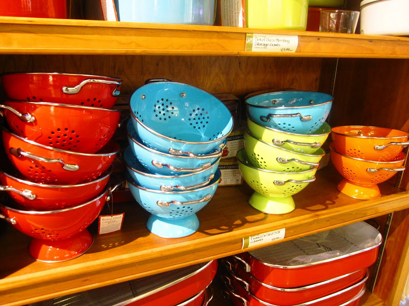 brightly colored colanders on a wood shelf at Whole Foods