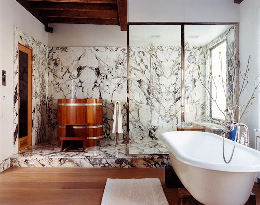Bathroom with colorful marble in the shower area which is also adorned with a standing wood soaking tub, wood floor, and a stand alone tub