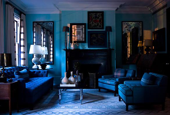 Royal blue living room with a black fireplace, tufted blue sofa and armchairs, molded detailing on the ceiling and a blue patterned floor