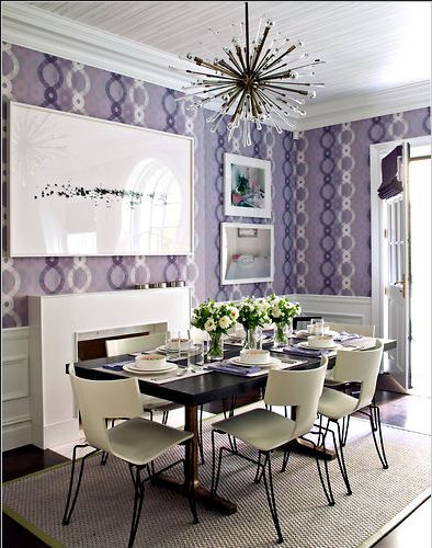 Dining room with lavender wallpaper, white fireplace, wood floor, sisal rug and Sputnik chandelier