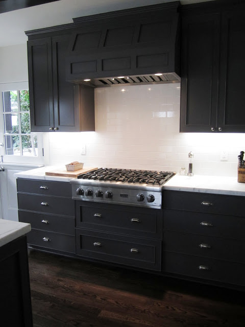 Kitchen with a Viking gas range with a paneled hood painted grey to match the cabinets and drawers