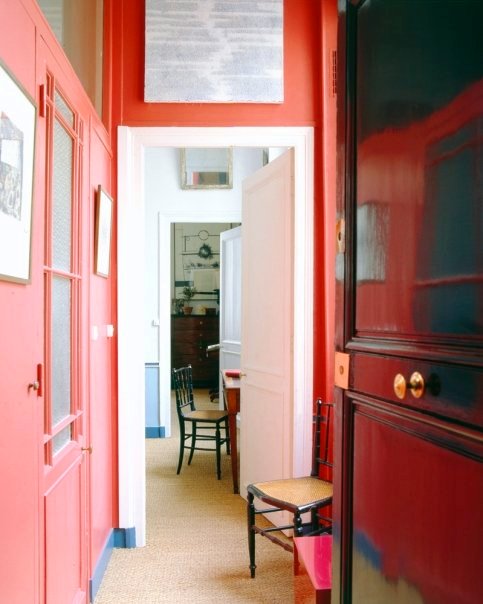 Coral hallway with a white door in a Paris apartment 