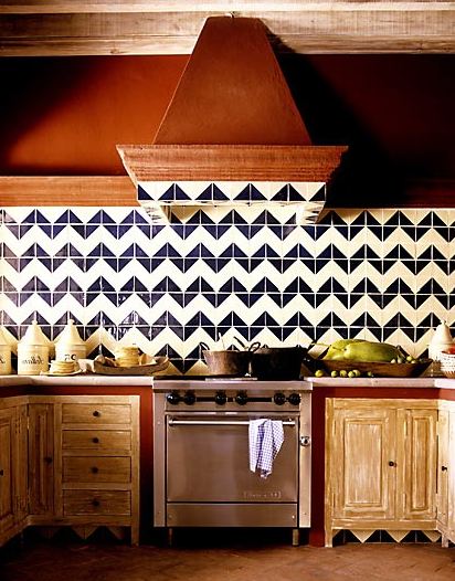 Kitchen with reclaimed wood cabinets and drawers, stainless appliances and a blue and white chevron tile backsplash
