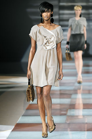 Model from Emporio Armani's Fall Ready-to-Wear 2010 fashion show wearing a grey dress with a large flower
