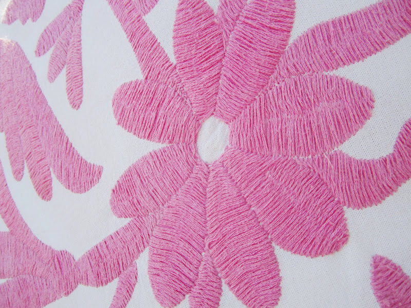 close of the embroidery on the pink bench pillow